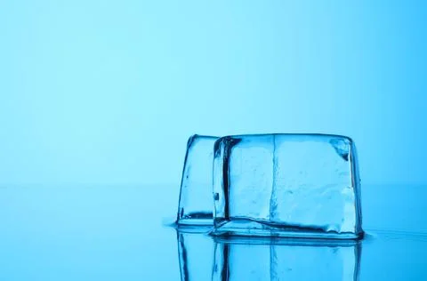 Cubes of clear ice on light blue background, closeup. Space for text Foto stock