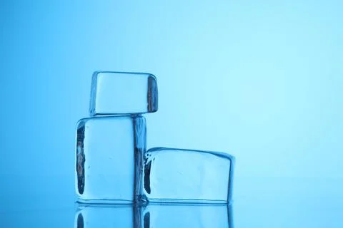 Cubes of clear ice on light blue background, closeup. Space for text Stock Photos