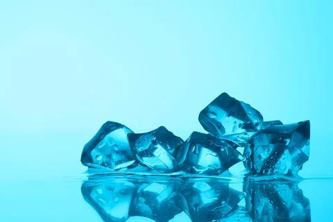 Cubes of clear ice on light blue background, closeup. Space for text Stock Photos