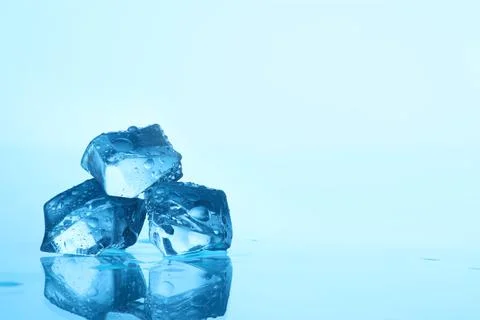 Cubes of clear ice on light blue background, closeup. Space for text Stockfoto's