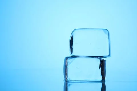 Cubes of clear ice on light blue background, closeup. Space for text Stock Photos