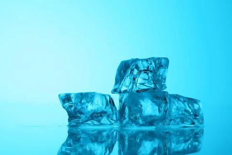 Cubes of clear ice on light blue background, closeup. Space for text Stock Photos