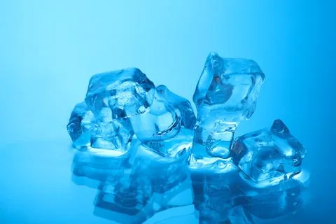 Cubes of clear ice on light blue background, closeup Stock Photos