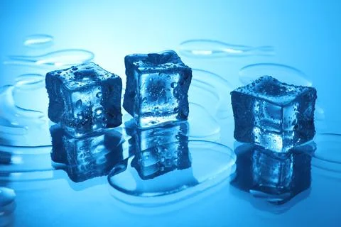 Cubes of clear ice on light blue background Stock Photos