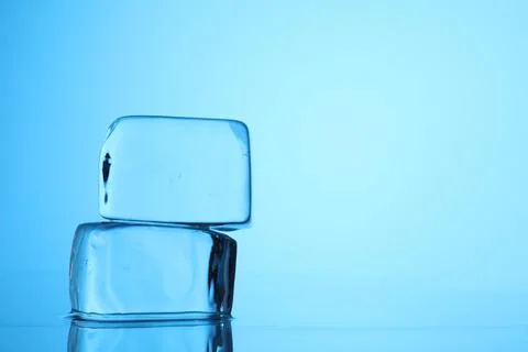 Cubes of clear ice on light blue background, closeup. Space for text Stock Photos