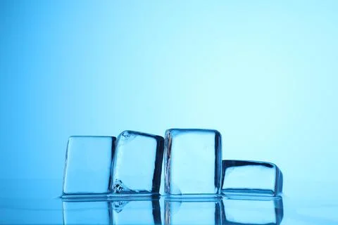 Cubes of clear ice on light blue background, closeup. Space for text 스톡 사진