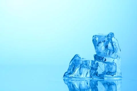 Cubes of clear ice on light blue background, closeup. Space for text Stock Photos