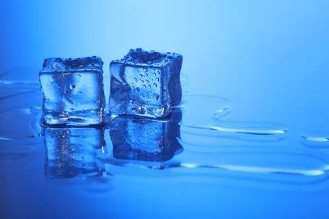 Cubes of clear ice on light blue background, space for text Stock Photos