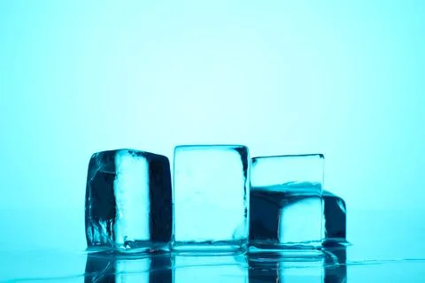 Cubes of clear ice on light blue background, closeup. Space for text Stock Photos