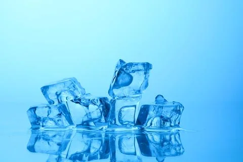 Cubes of clear ice on light blue background, closeup. Space for text 스톡 사진