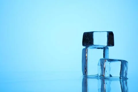 Cubes of clear ice on light blue background, closeup. Space for text 스톡 사진
