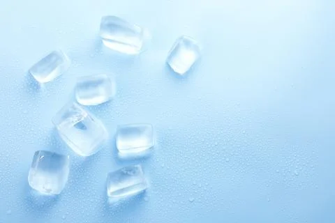 Cubes of clear ice on light blue background, flat lay. Space for text Foto stock