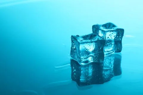 Cubes of clear ice on light blue background, space for text Foto stock