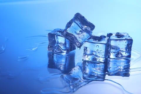 Cubes of clear ice on light blue background, space for text Stock Photos
