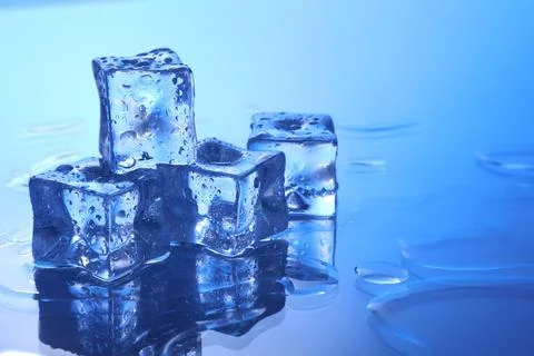 Cubes of clear ice on light blue background, space for text Stockfoto's