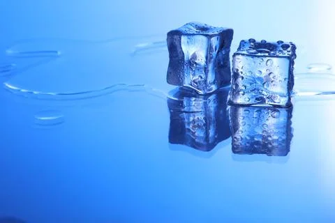 Cubes of clear ice on light blue background, space for text Stock Photos