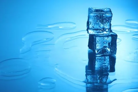 Cubes of clear ice on light blue background, space for text Stock Photos