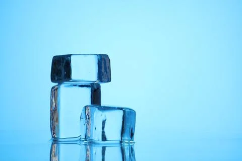 Cubes of clear ice on light blue background, closeup. Space for text Stock Photos