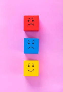 Cubes with cute faces depicting human emotions: anger, sadness and happiness Foto stock