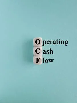 Cubes form the acronym OCF-operating cash flow. Beautiful blue background Stock Photos