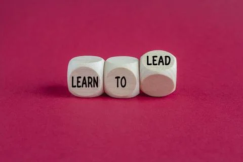 Cubes form the expression Learn to Lead. Beautiful red background, copy space Stock Photos