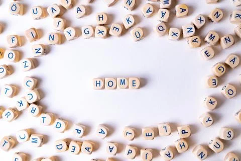 Cubes with letters building the word "Home" in the middle of random cubes lay Stock Photos