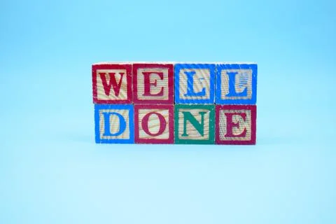 Cubes with message WELL DONE in front of a brick wall Stock Photos