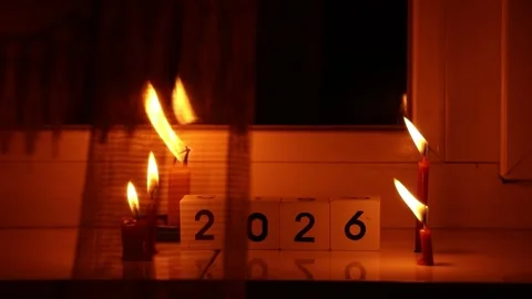 Cubes with the number 2026 and burning candles on a windowsill Stock Footage 323639331