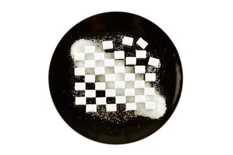 Cubes of refined sugar laid in a pattern on a black plate, crystal sugar scat Foto stock
