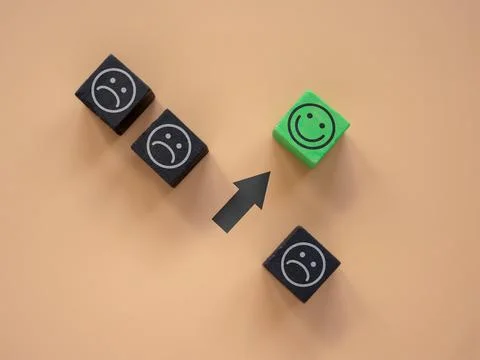 Cubes with sad faces and one with happy ones. Positive thinking and new mindset 스톡 사진