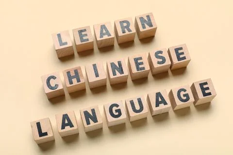 Cubes with text LEARN CHINESE LANGUAGE on beige background Stock Photos