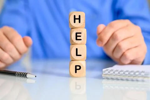 Cubes on top of each other making the word help with a man in the background Stock Photos