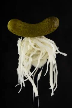 Cucumber and cabbage on a fork on a dark background Stock Photos