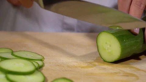 Cucumber being cut on chopping board Stock Footage 79473420