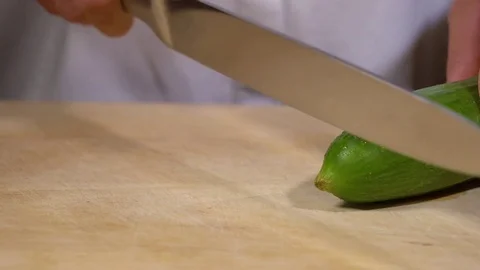 Cucumber being cut on chopping board Stock Footage
