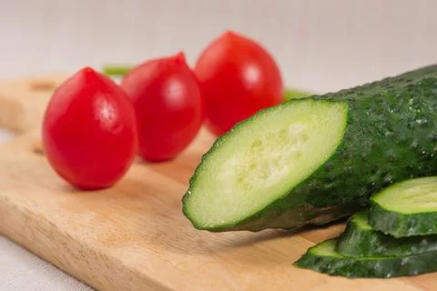Cucumber, cherry tomatoes on the Board close-up. Selective focus Stock Photos