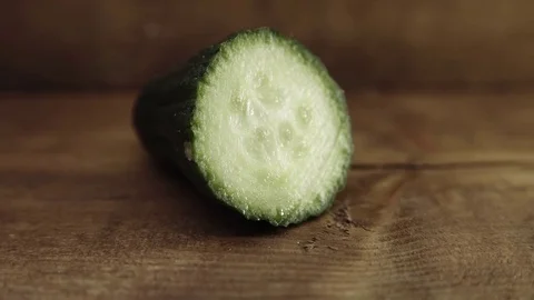 Cucumber cut in half rustic background UHD stock footage Stock Footage 82576026
