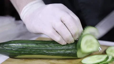 The cucumber is cut into round slices close-up. cucumber on a wooden board Stock Footage 158179323