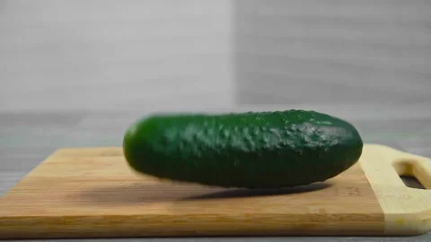 Cucumber falls on a cutting board Stock Footage 194163287