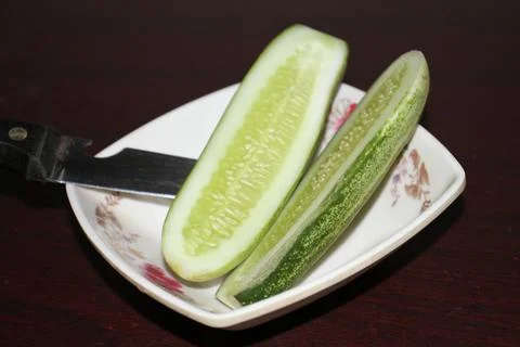 The cucumber with knife. Stock Photos