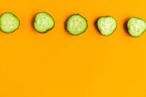 Cucumber pattern on bright orange background. Minimal concept. Copy space for Stock Photos