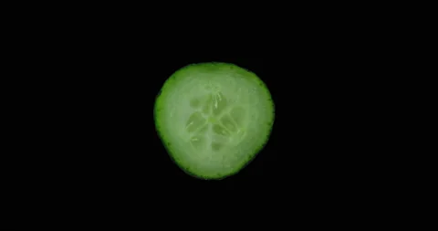Cucumber slice rotating with black background Stock Footage 233548207