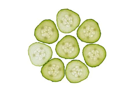 Cucumber slices arranged in a circular pattern, vibrant green cross-sections  Stock Photos