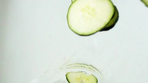 Cucumber Slices Falling Down Splashing Right Side Slow Motion Video stock 246989103