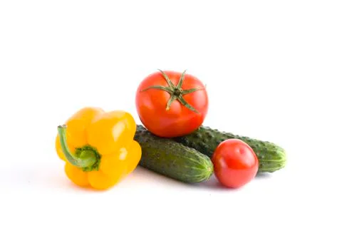 Cucumber with tomato and pepper on a white background. Vegetables on a white Stock Photos