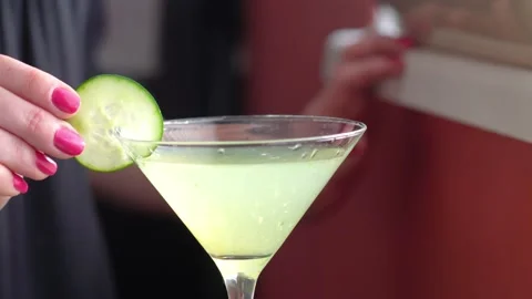 Cucumber Wheel Slice Garnish is Placed on a Martini Glass Filled with a Video stock 155146687