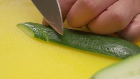 Cucumbers are cut into strips on yellow board by the chief Stock Footage 221415241