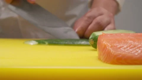 Cucumbers are cut on yellow board by the chief Stock Footage 231015919