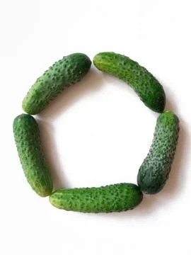 Cucumbers arranged in circle shape on white background Stock Photos