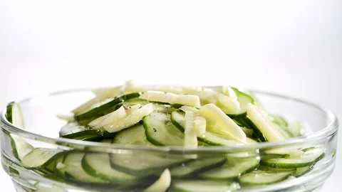 The cucumbers cut by thin slices with garlic in ware from glass sprinkle ground Stock Footage 79656842